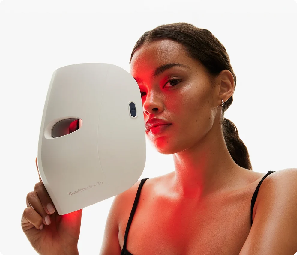 Person holding an LED light therapy face mask