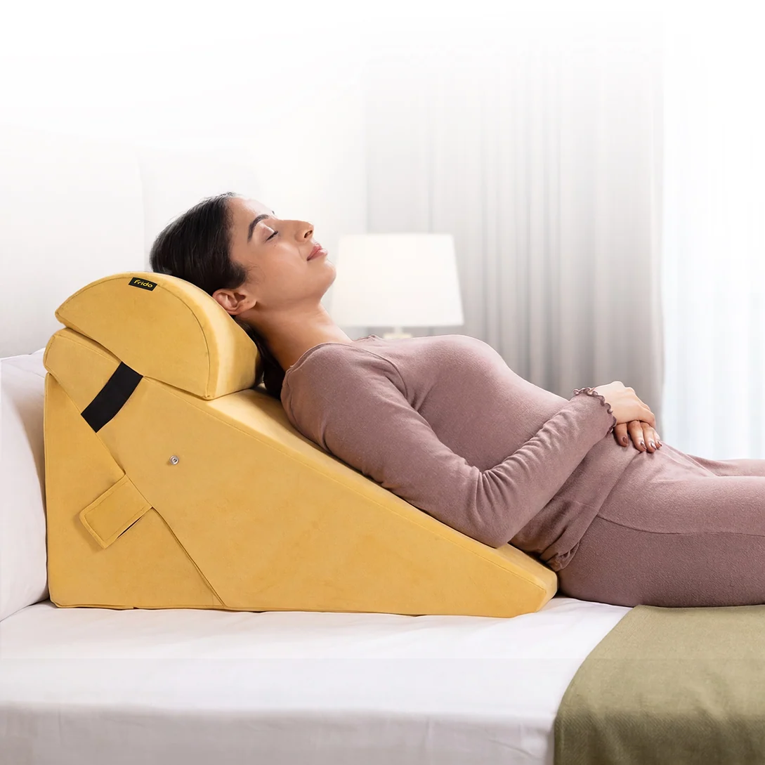 A person reclining against a supportive wedge cushion